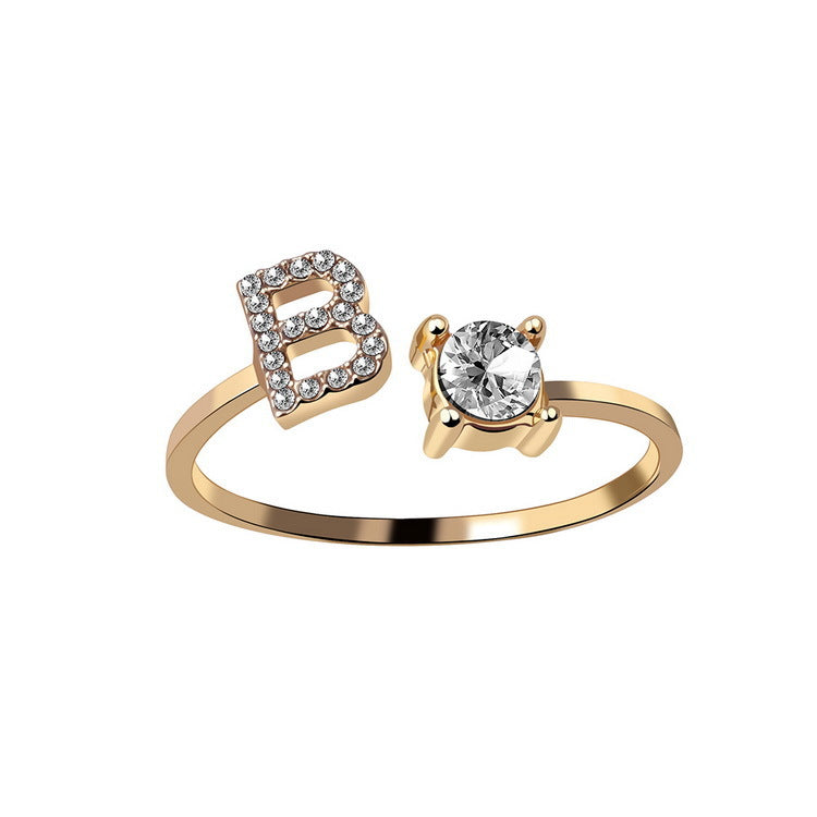 Initial letter ring in gold shown on a hand