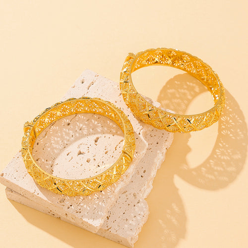 Close-up of the hollow four-leaf clover motif on the gold-plated bracelet